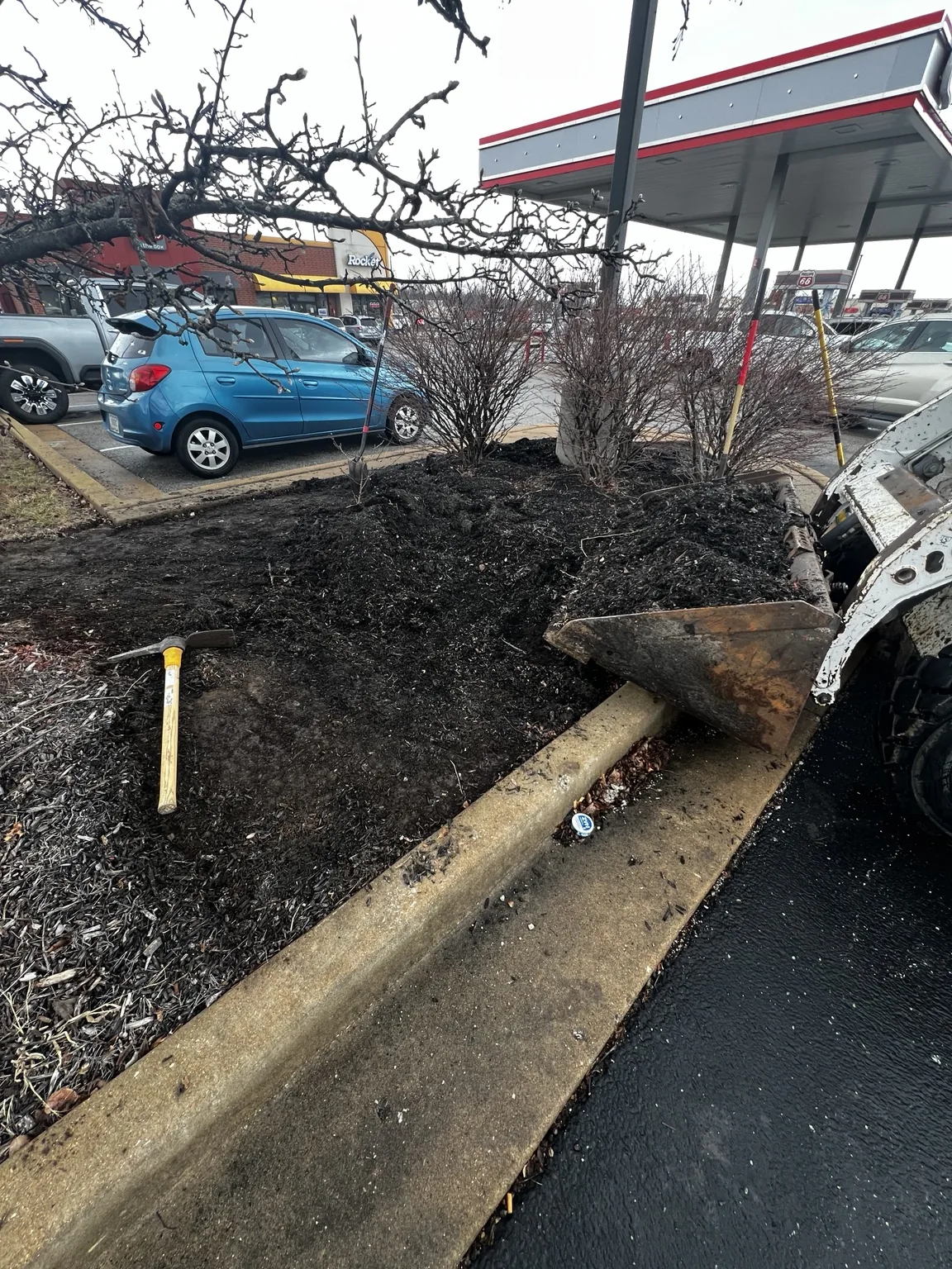 Brown hardwood mulch being installed in a commercial bed