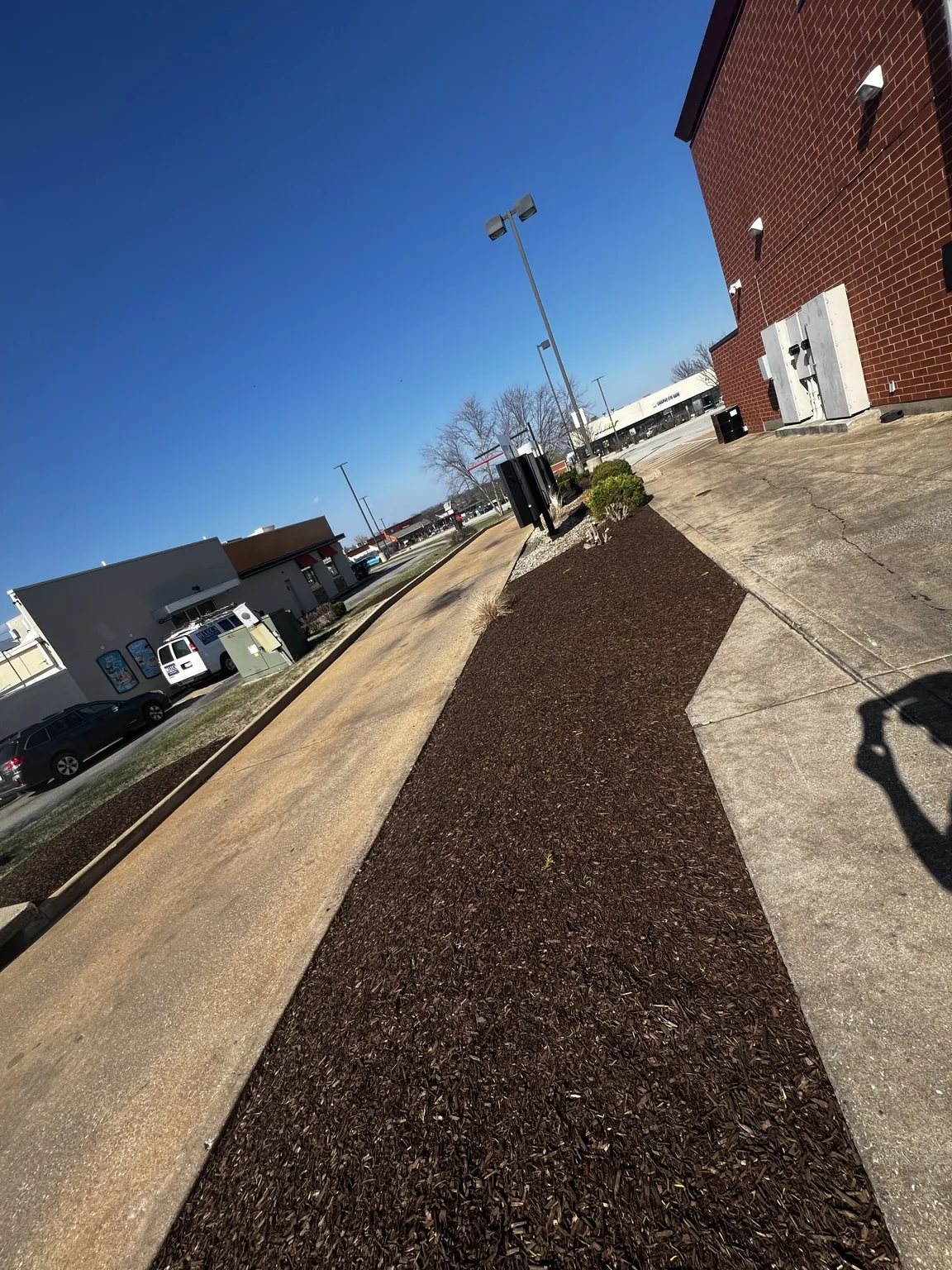 Long finished commercial mulch bed beside a building