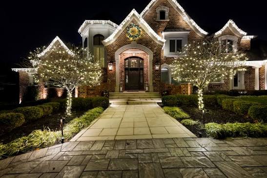 Warm-white roofline and tree lighting on a home