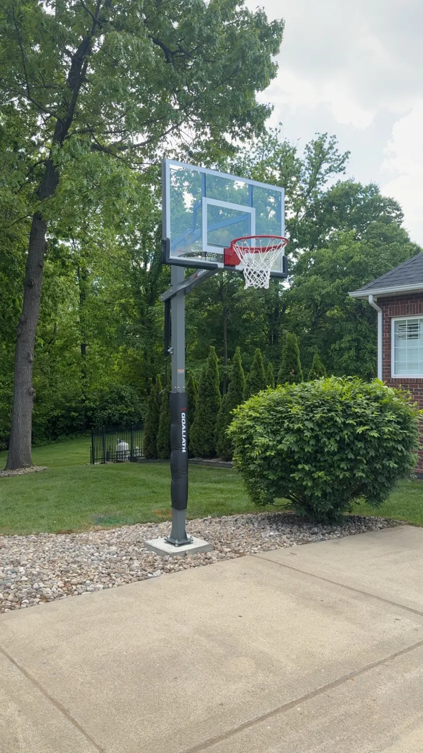 Completed in-ground basketball hoop beside a residential driveway