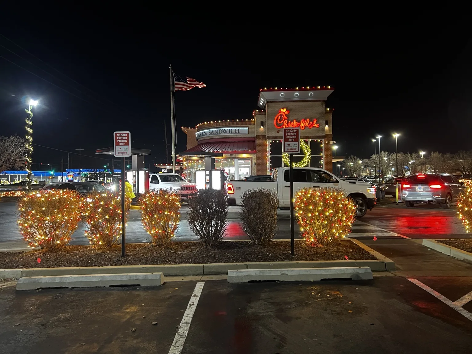 Illuminated shrubs and commercial entry at night