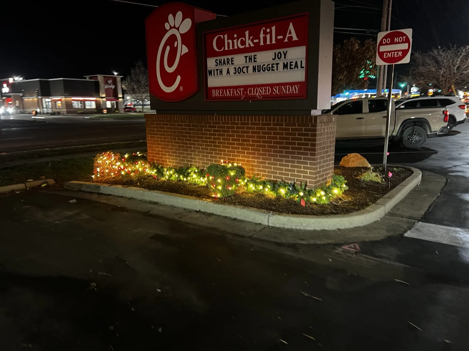 Commercial monument sign with Christmas lights in its planting bed