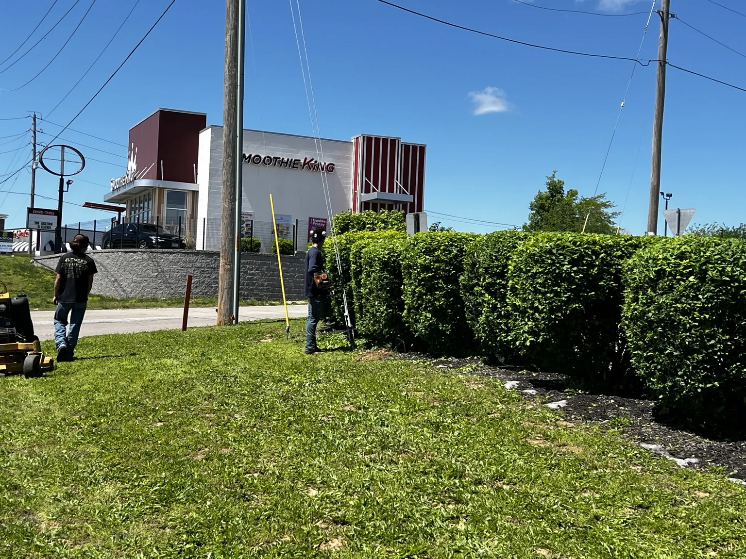 Crew shaping the hedge line at a commercial property