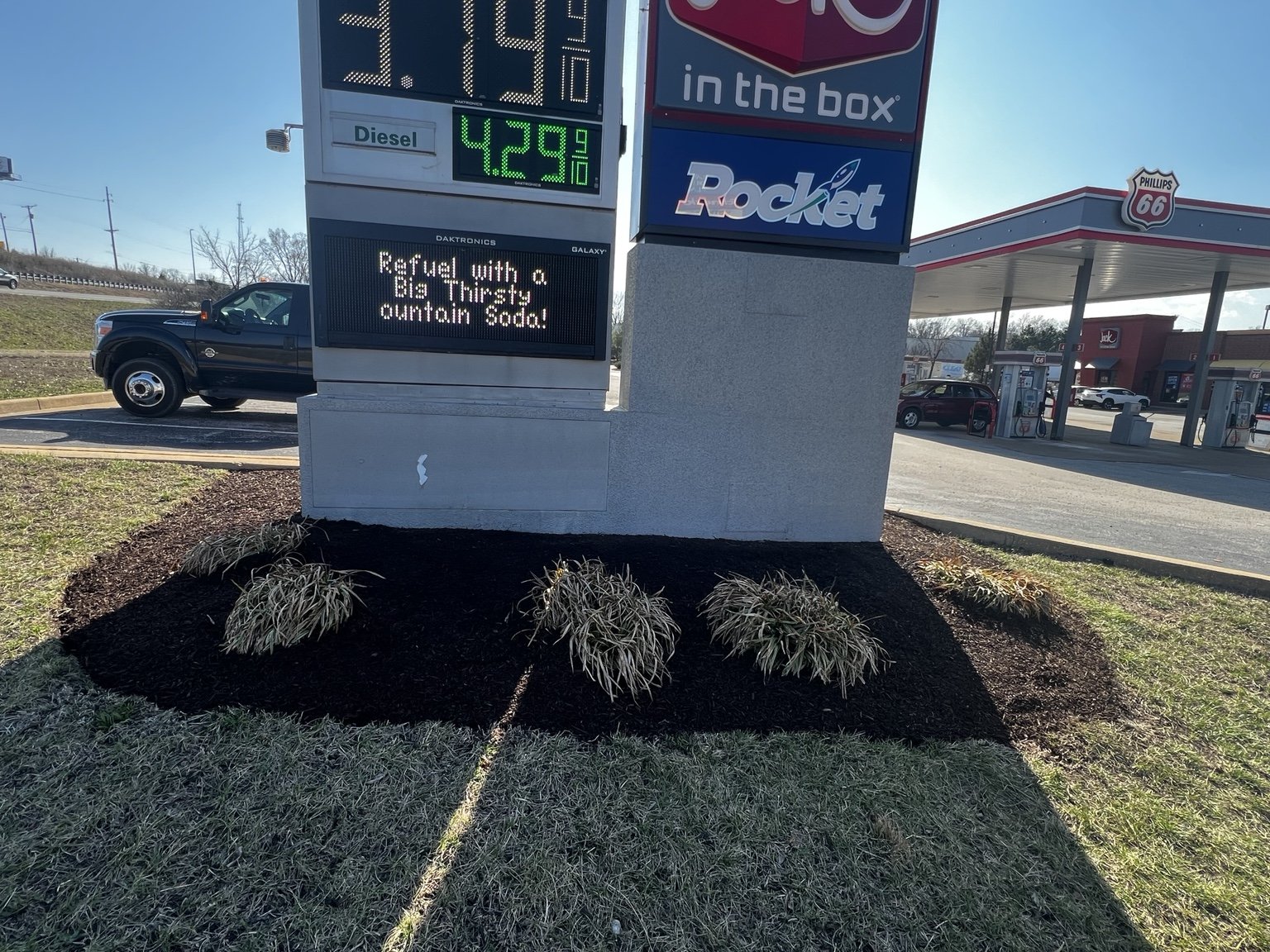 Commercial sign bed with maintained shrubs and mulch