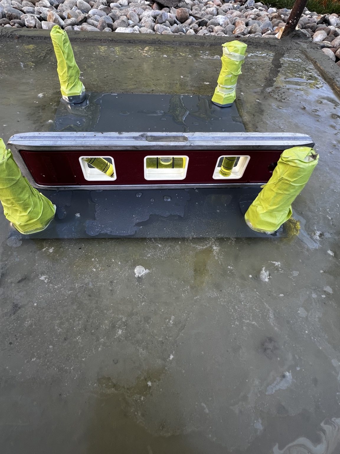 Anchor bolt plate checked for level in the fresh concrete