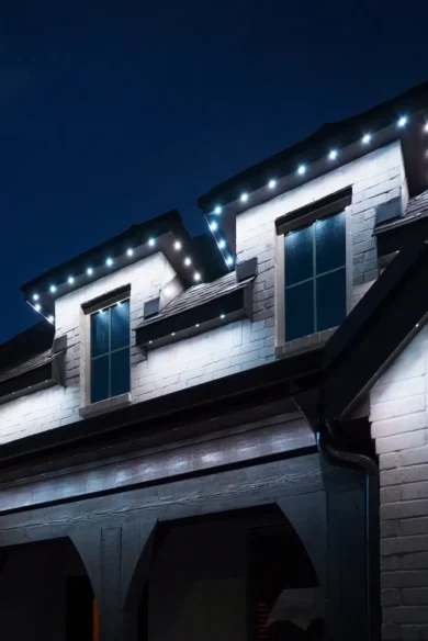 White eave lighting illuminating dormer windows and exterior siding at dusk