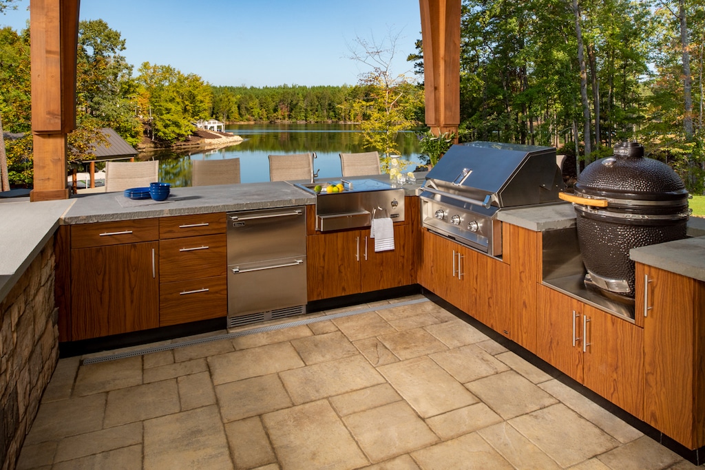 Outdoor kitchen with wood cabinetry and lakeside view