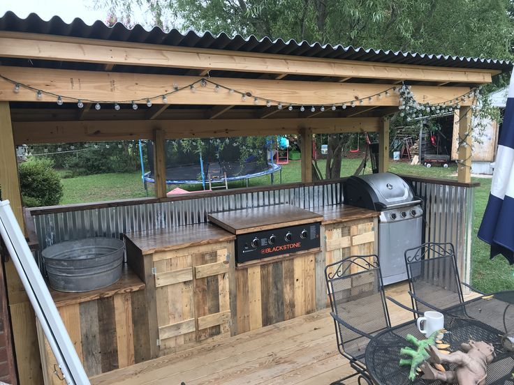 Rustic covered grilling station with wood cabinetry