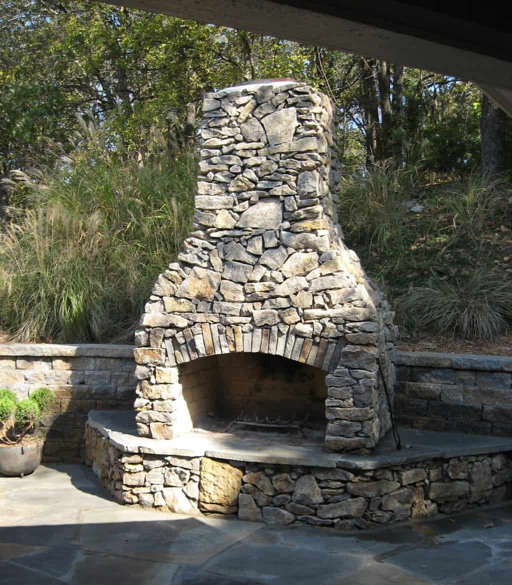 Natural stone outdoor fireplace with curved hearth