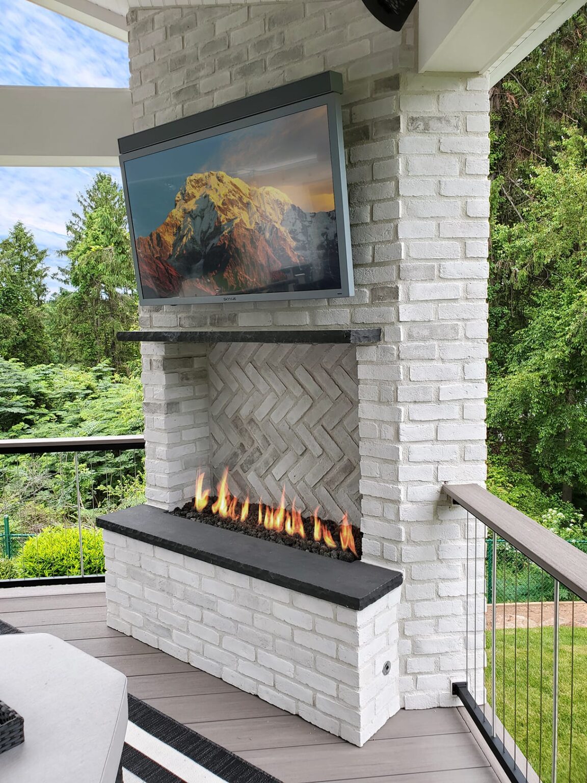 White brick outdoor fireplace with linear flames
