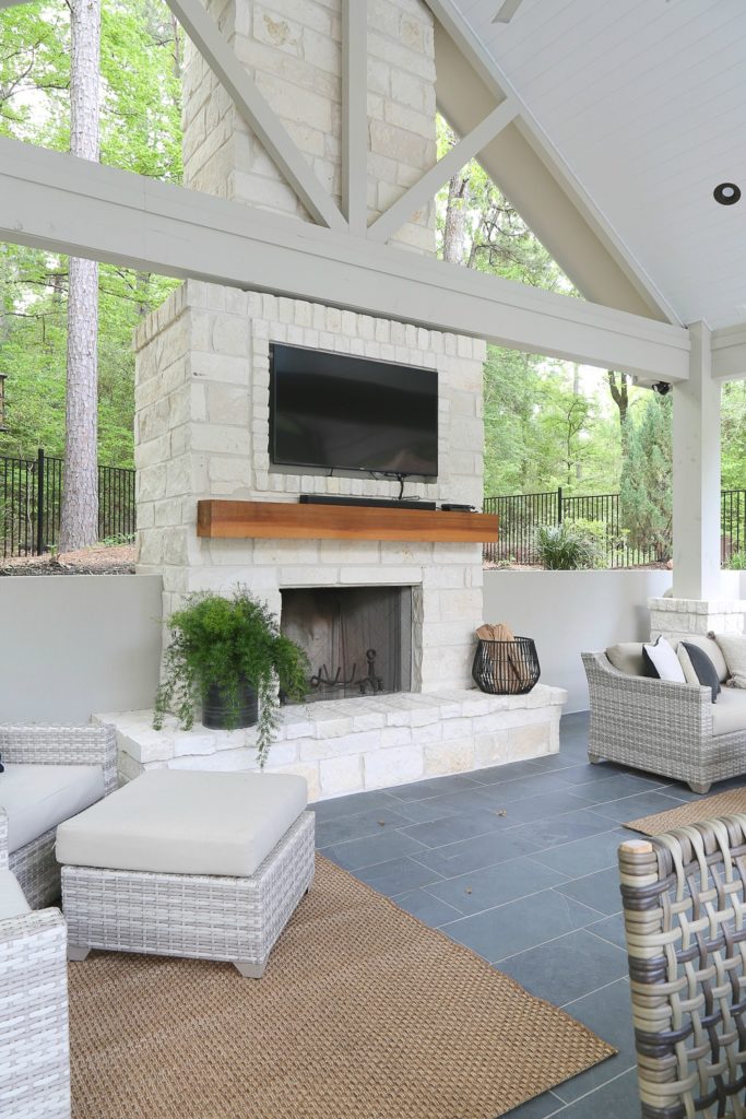 White stone fireplace beneath a vaulted patio roof