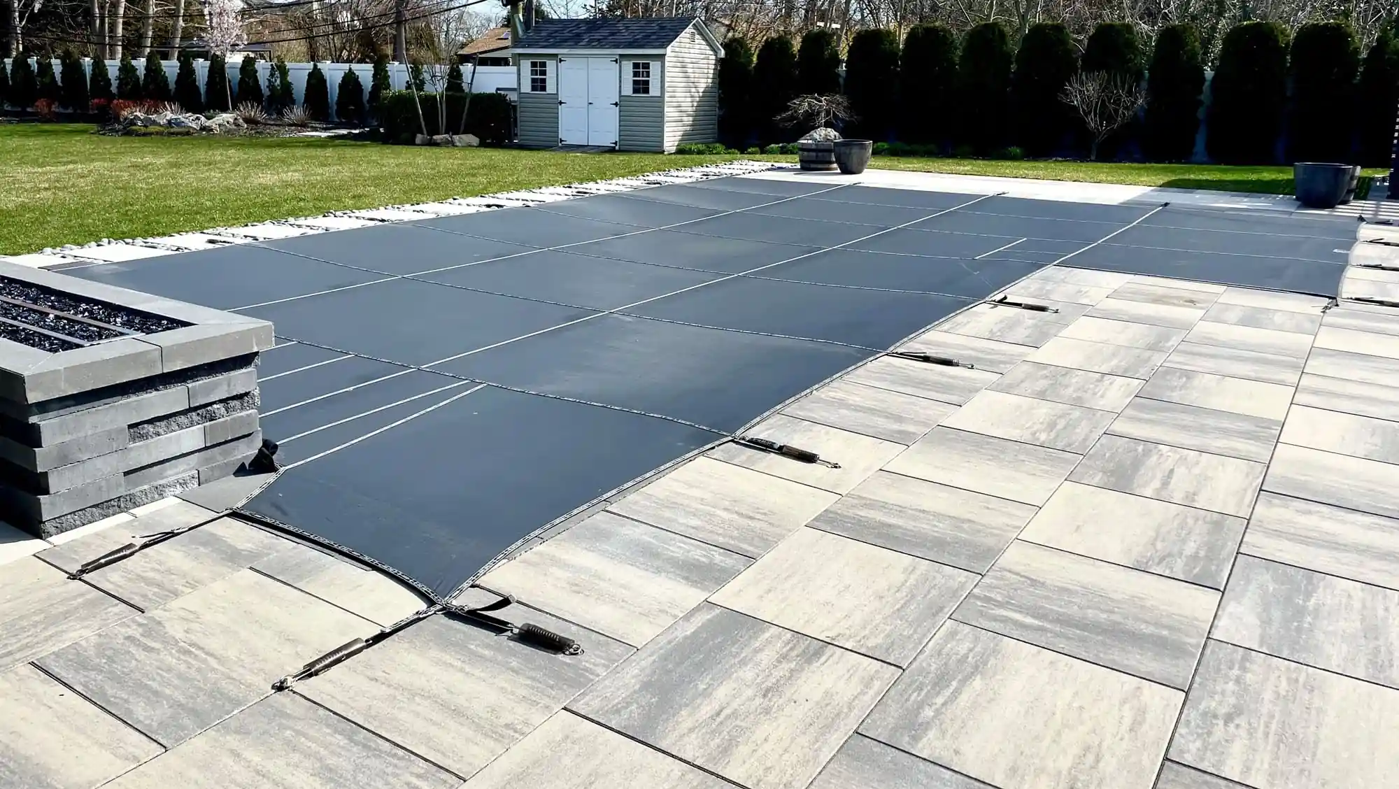 Large paver pool surround with a fitted pool cover