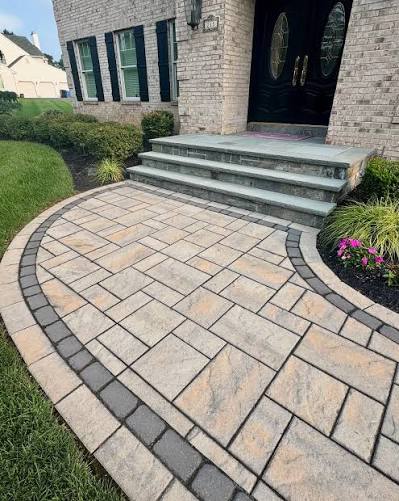 Curved paver entry walkway with dark border and front steps